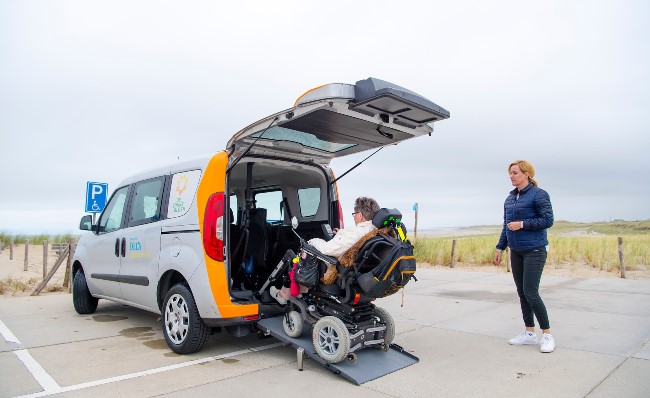 Ria Verhappen naar het strand met de Zonnebloemauto