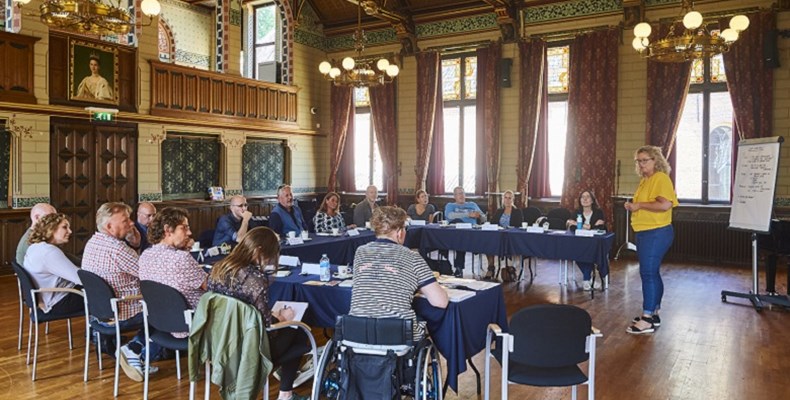 Medewerkers van het Drents Museum luisteren naar de workshopleider van de Zonnebloem tijdens een toegankelijkheidsworkshop