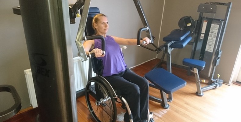 Rolstoelbasketballer Saskia Pronk traint op aangepaste fitnessapparatuur haar spieren