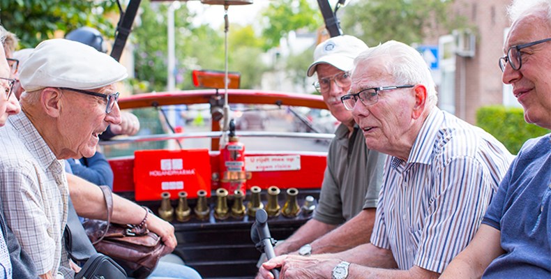 De mannen van afdeling Beltrum tijdens een rondrit in een oldtimer brandweerwagen.