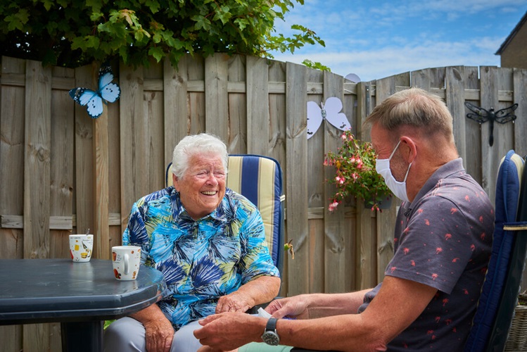 Bezoek aan huis met mondkapje in coronatijd