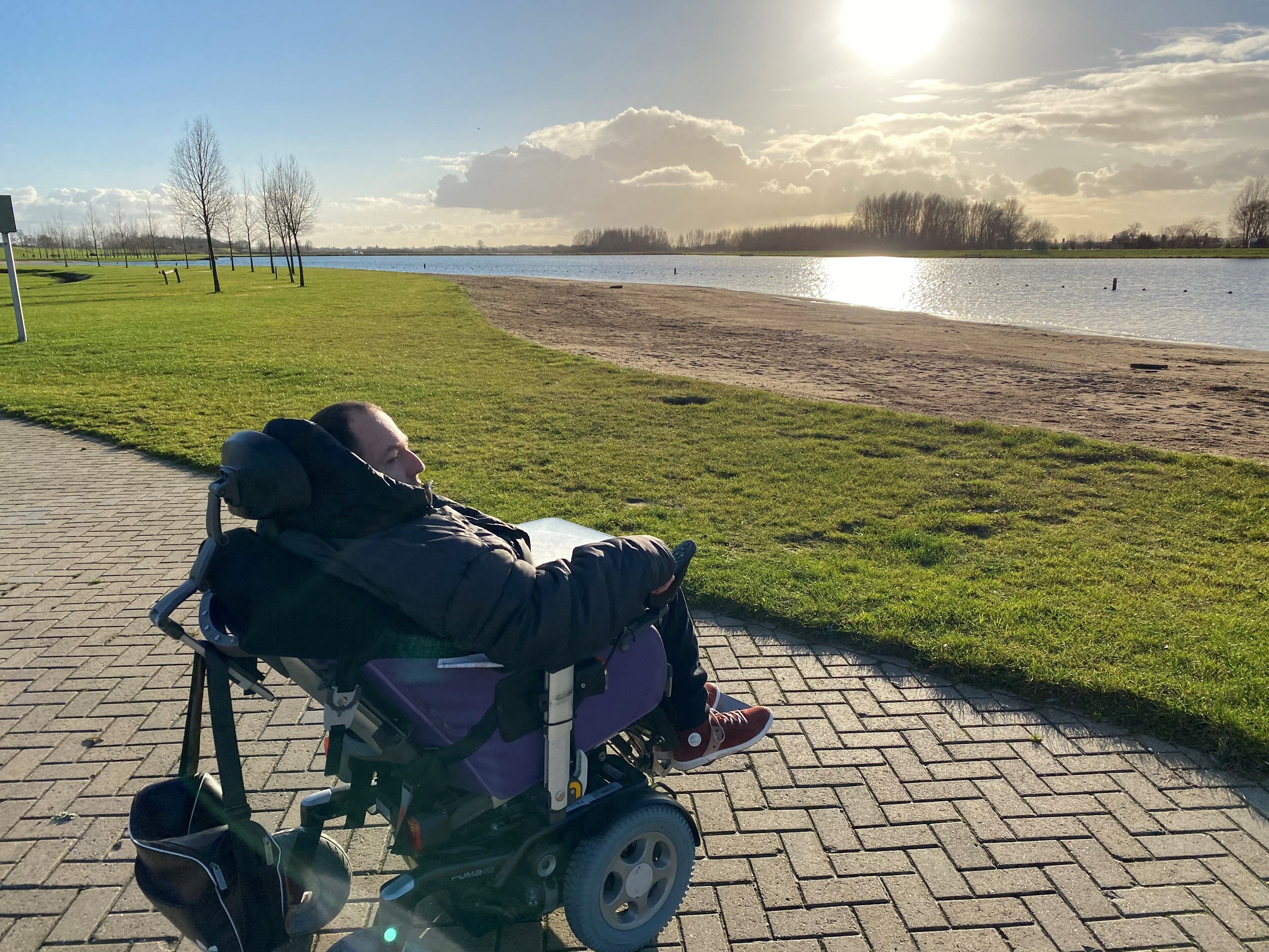 Pim in rolstoel kijkend naar de zonsondergang