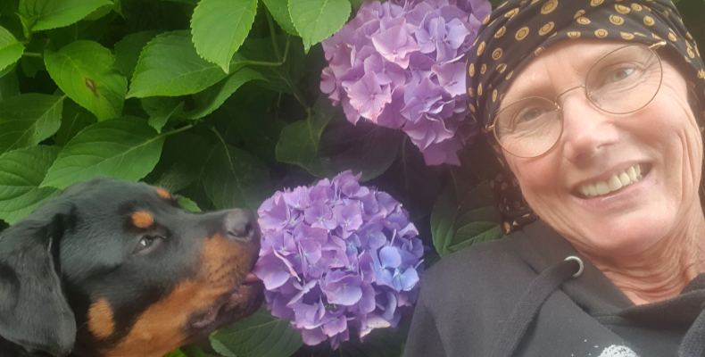 Selfie van Lilian samen met hond bij een paarse hortensia