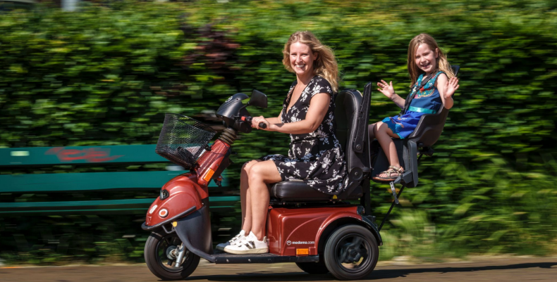 Sanne en Rosie rijdend in scootmobiel