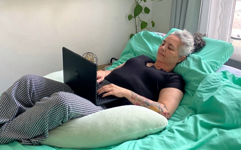 Blogger Max liggend op bed met haar laptop op schoot