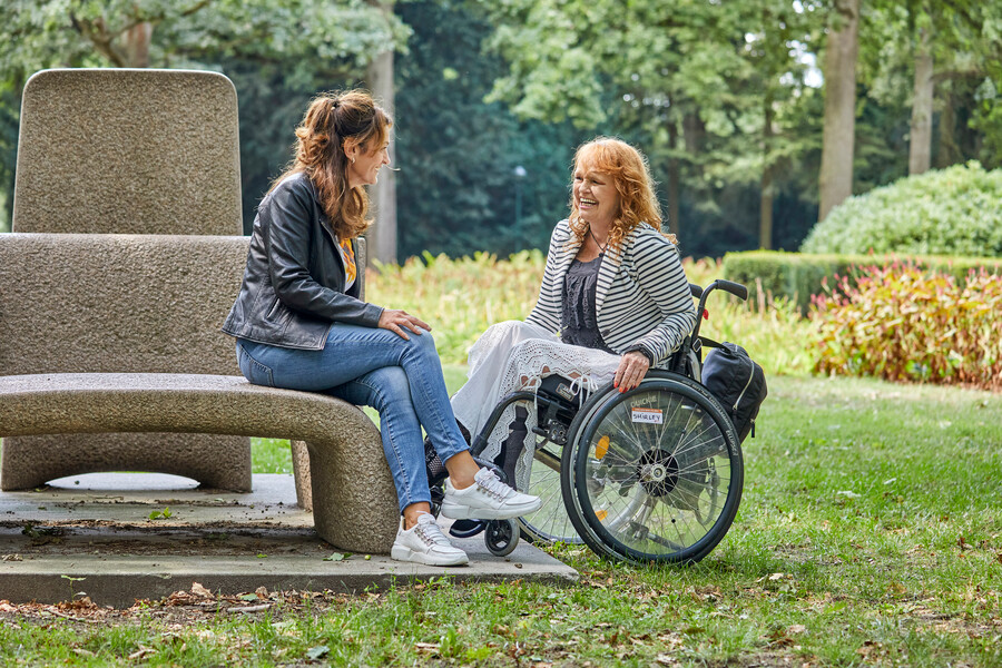Drie personen met een lichamelijk beperking die een rood potlood in de hand hebben