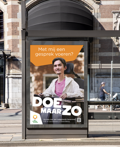Poster van Endri bij een tramhalte met de tekst: Met mij een gesprek voeren? Doe maar zo!